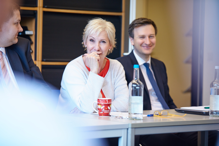 Drei Mitarbeiter/innen im Gespräch beim Meeting