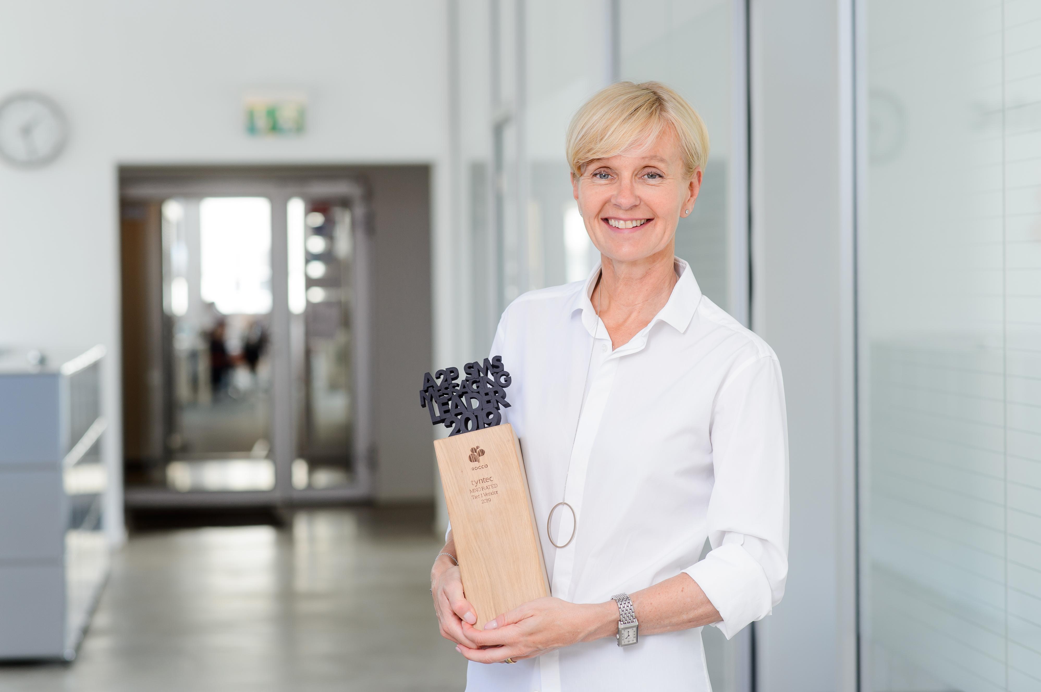 Our CEO, Nicola Wolfram, showing off our reward for being a Tier 1 A2P SMS messaging leader!
