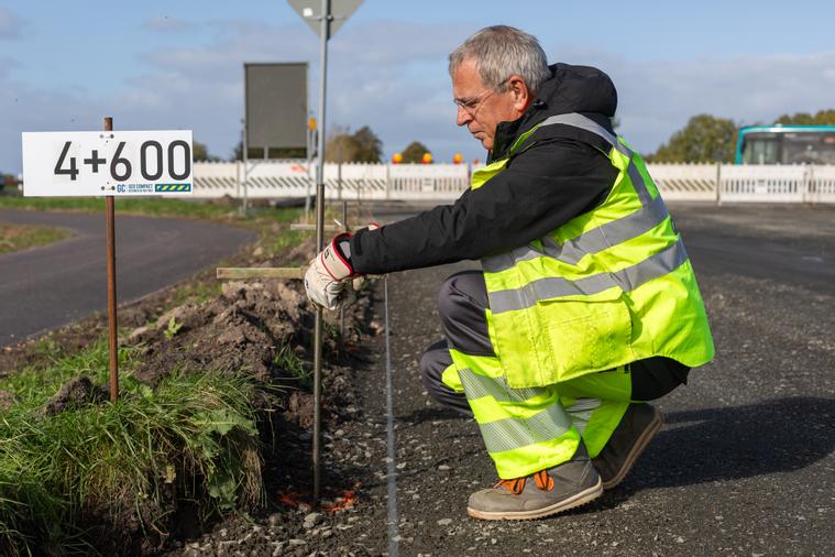 Mitarbeiter beim Einrichten des Leitdrahtes für den Straßenbau