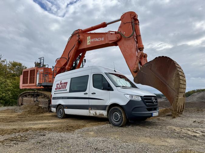 Montagewagen auf der Baustelle vor einem 120to. Bagger