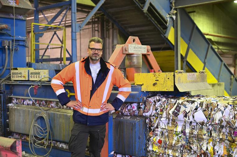 Ausbildungsbeauftragter vor Papierpresse