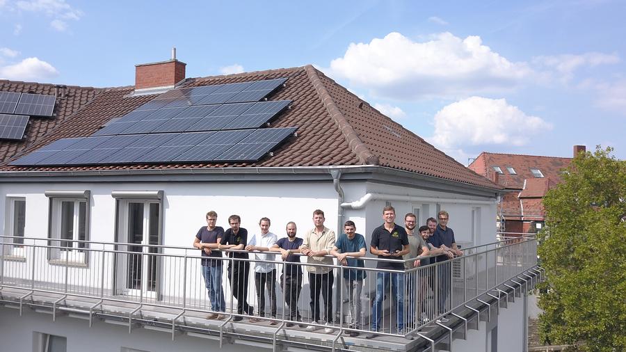 EnQS-Team auf unserer tollen Terrasse mit Photovoltaik-Anlage auf dem Dach.