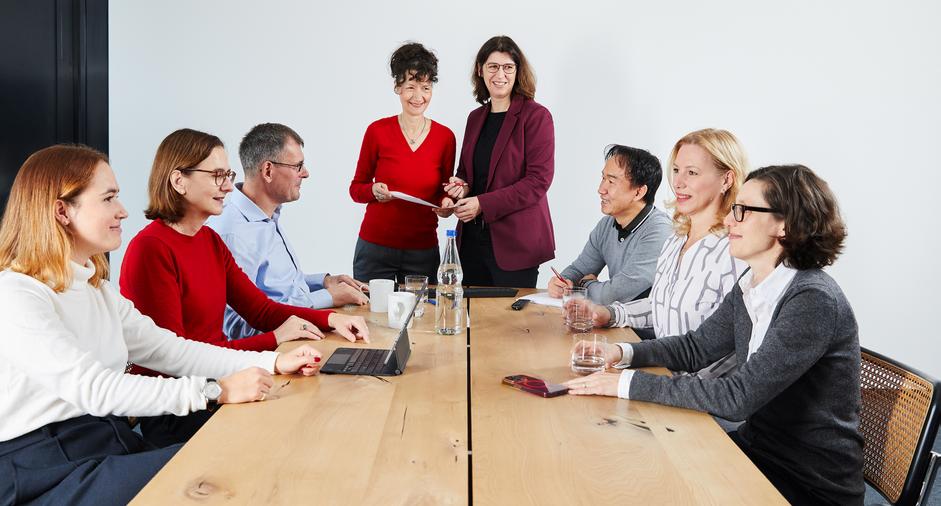 Eine Gruppe von Mitarbeitenden hält eine Besprechung in einem Konferenzraum ab.